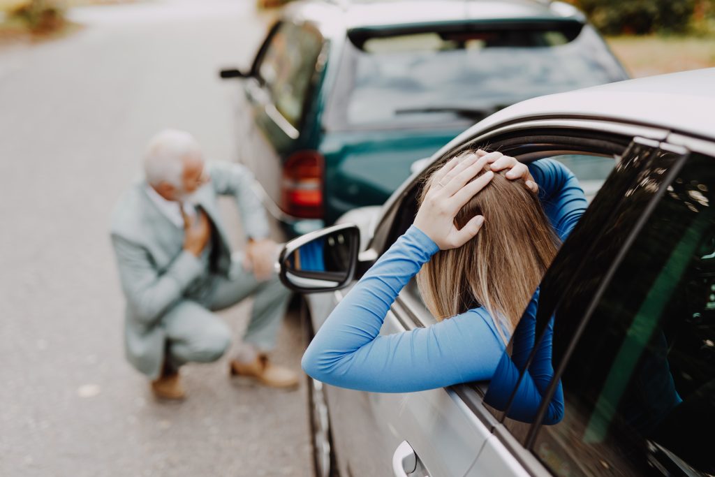 Hombre mayor y mujer joven discutiendo tras accidente de coche. Por qué necesita un abogado experto en accidentes automovilísticos en Atlanta