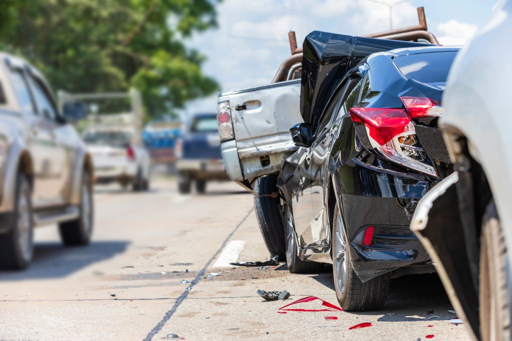 Una colisión por alcance en la que se vieron implicados varios vehículos en una carretera muy transitada, con importantes daños en un coche negro y restos esparcidos por la calle.