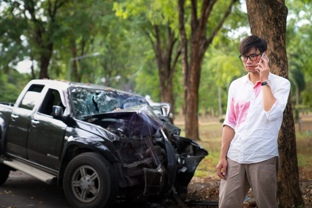A man stands by a wrecked car, illustrating the consequences of a car accident, emphasizing the need for legal assistance in Tucker, GA.